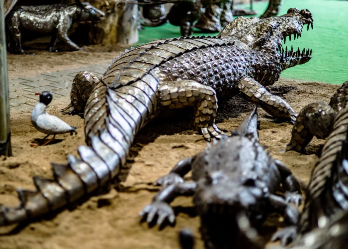 Eine lebensgroßes Metallfigur eines Krokodils sperrt sein Maul auf